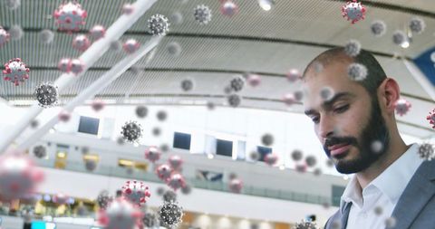 Businessman at airport amidst digital virus graphics