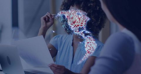 Professional reviewing documents with holographic data globe over laptop for futuristic collaboratio