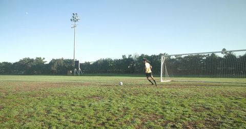 Athletic male soccer player on field near goal in dynamic action