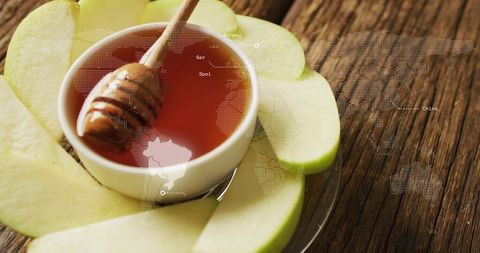 Rustic honey and green apple platter with wooden dipper, warm amber nectar and world map overlay