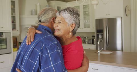 Elderly Couple Embracing in Modern Kitchen - Download Free Stock Images Pikwizard.com