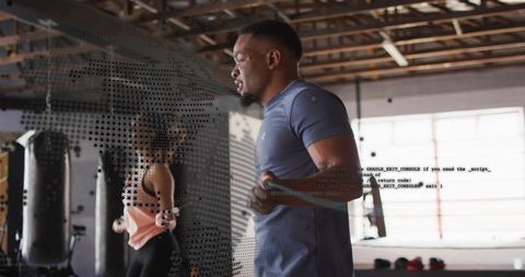 Man jumping rope during high-intensity gym cardio with punching bags and halftone overlay