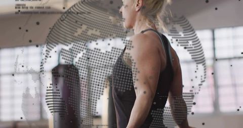 Athletic woman training with punching bag and dotted globe overlay for fitness branding