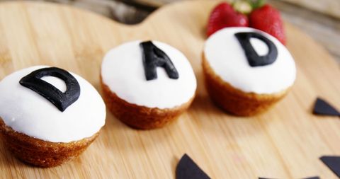 Father's day cupcakes spelling 'dad' on wooden board