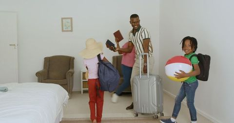 Happy Family Packing Suitcase for Vacation in Cozy Bedroom