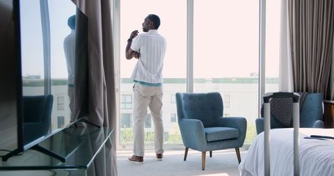 Thoughtful man seeking inspiration by hotel window