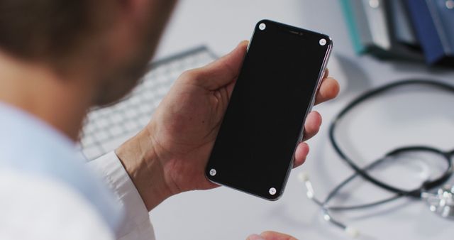 Doctor Holding Smartphone by Medical Desk with Stethoscope - Download Free Stock Images Pikwizard.com