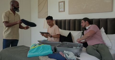 Friends Packing Luggage for Wedding Celebration in Bedroom
