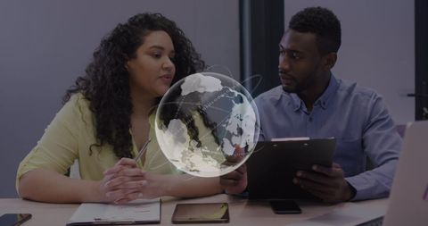 Digital globe and diverse colleagues collaborating in office