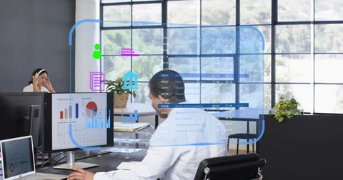 Business professional working at desk with holographic financial dashboards and analytics