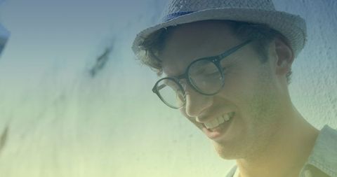 Smiling Man Wearing Hat and Glasses Outdoors