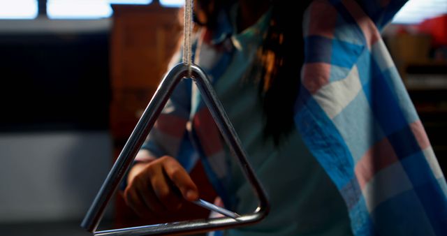 Blurry Close-Up of Person Playing Triangle Percussion Instrument - Download Free Stock Images Pikwizard.com