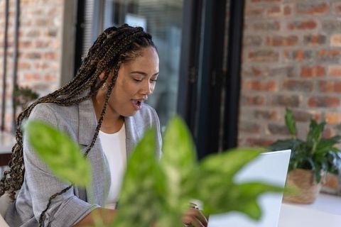 Focused Professional Woman Typing on Laptop at Office Desk