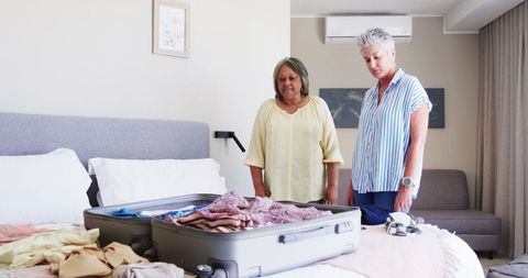 Senior Women Packing Suitcase for Travel in Cosy Bedroom