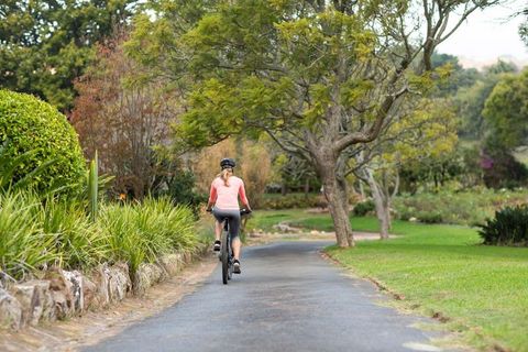 Female cyclist exploring scenic park trail on autumn day