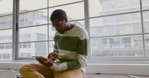 African American Businessman Using Digital Tablet in Modern Office