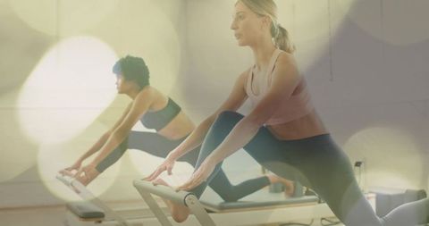 Women Doing Reformer Pilates Lunge for Core Strength, Flexibility and Balance in Studio