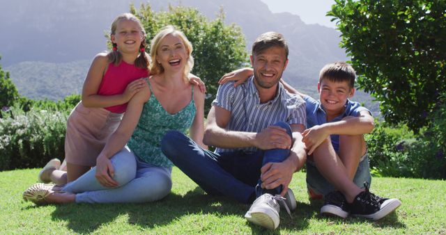 Portrait of caucasian family smiling together while sitting in the garden on a bright sunny day. family, love and togetherness concept