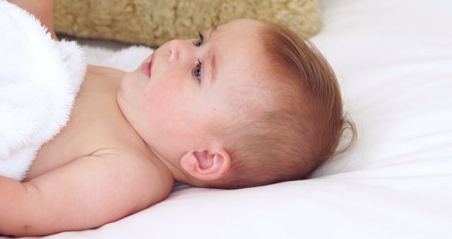 Cute baby lying on a bed at home in bedroom