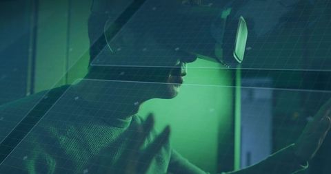 Korean man wearing VR headset and cap reaching toward holographic HUD in neon green lab