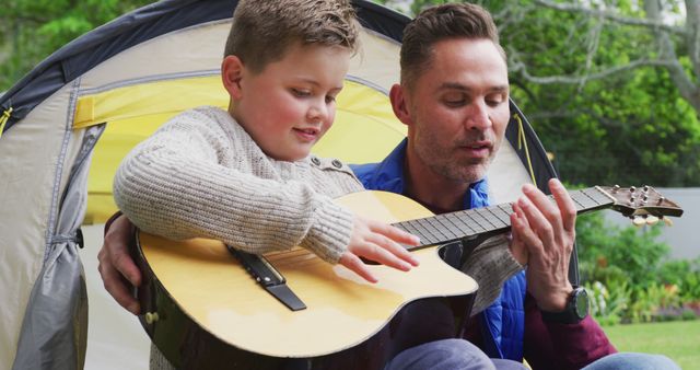 Father Teaching Son to Play Guitar During Outdoor Camping - Download Free Stock Images Pikwizard.com