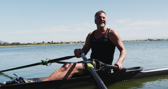 Senior caucasian man preparing rowing boat in a river. sport retirement leisure hobbies rowing healthy outdoor lifestyle.