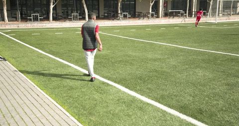 Coach Guiding Soccer Practice on Field