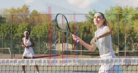 Female Doubles Players Engaging in Competitive Outdoor Tennis Match