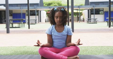 Young Girl Practicing Meditation in Schoolyard