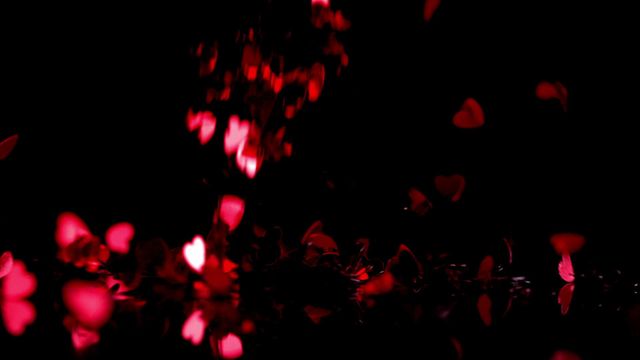 This video features falling red heart confetti on a black background captured in slow motion. Perfect for use in romantic and festive contexts such as Valentine's Day promotions, wedding invitations, and love-themed projects. The vibrant red hearts against the dark background create a striking contrast, making it ideal for adding a touch of romance and celebration to various digital and print media.