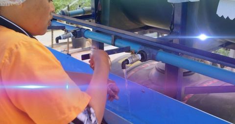 Blue Light Beam over Woman Washing Hands at Outdoor Standpipe