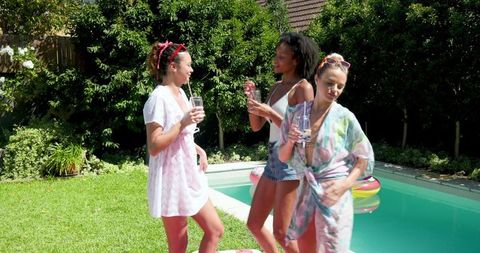 Group of Friends Relaxing by Backyard Pool on Sunny Day