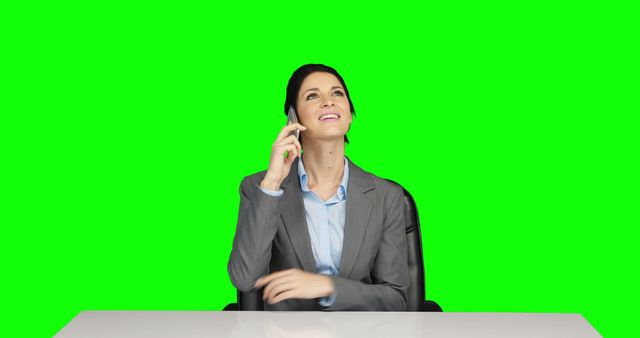 Businesswoman in a suit smiling while talking on phone, suitable for business, corporate, and communication-themed projects. Ideal for websites, advertisements, or promotional materials highlighting professional communication, office environments, or corporate culture against an easy-to-edit green screen background for flexible use in various media.