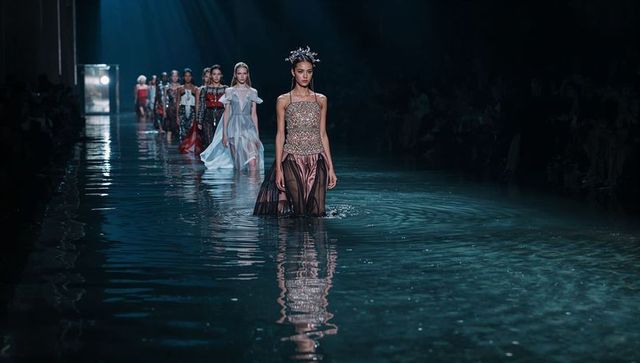 Elegant model gracefully walking runway over water