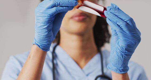 Image of biracial female doctor holding test tube on blue background - Download Free Stock Photos Pikwizard.com