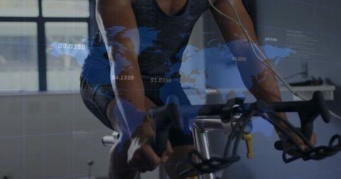 Indoor cyclist training on stationary bike with world map data overlay and earbuds