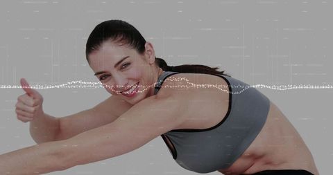 Energetic trainer in sporty pose with digital waveform