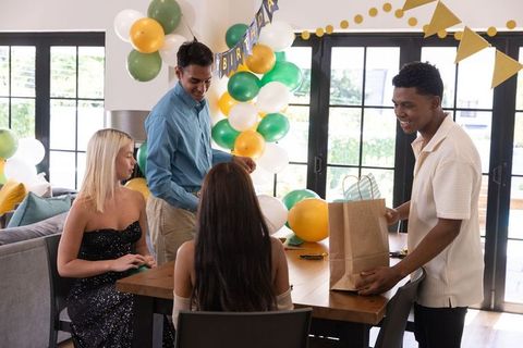 Diverse Friends Celebrating Birthday at Home with Gift Bags and Decorations