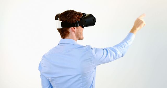 Businessman Using Virtual Reality Headset Gesturing with Finger in Office - Download Free Stock Images Pikwizard.com