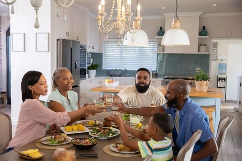 Multigenerational Family Celebrating with Cheers at Dining Table