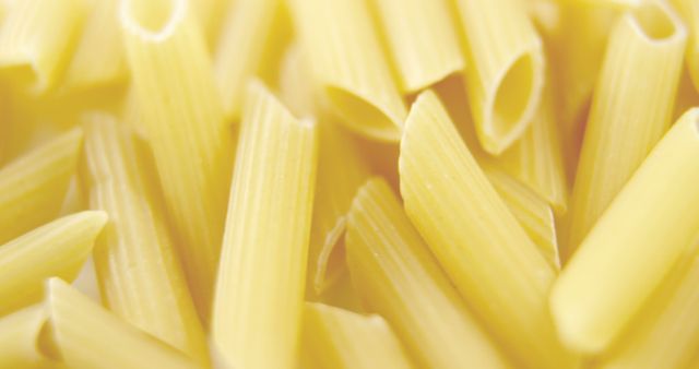 Close-up view of uncooked penne pasta with a soft focus background, with copy space. Penne is a popular pasta shape traditionally used in Italian cuisine.