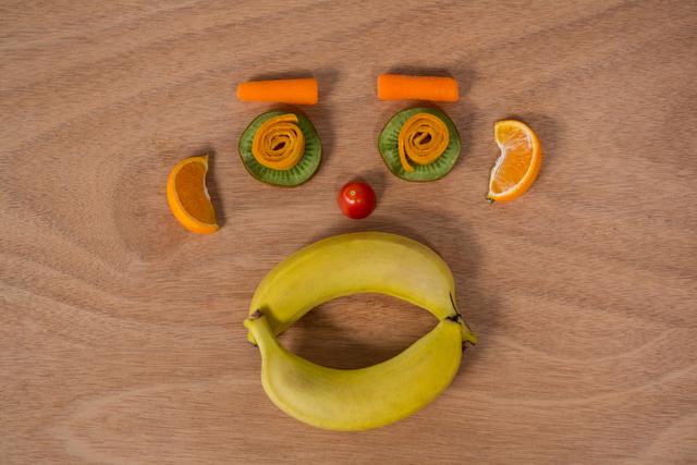 Face made up of various fruits on a table