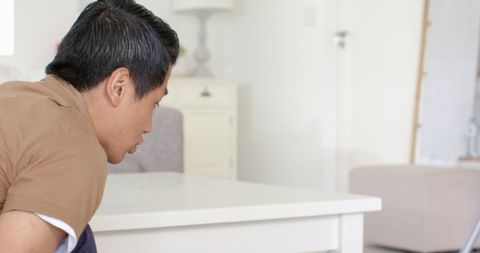Person cleaning under white coffee table in living room