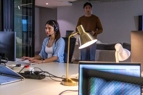 Female using headset working in modern open-plan office showing focused teamwork