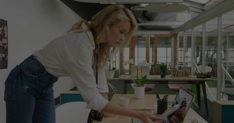 Focused entrepreneur adjusting laptop in modern coworking office