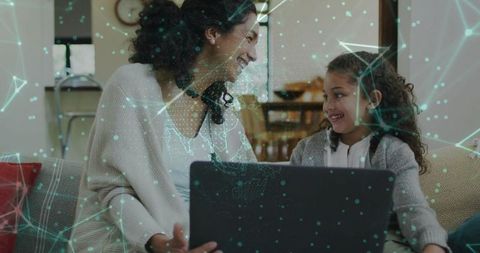 Parent and child sharing laptop on sofa with teal digital network overlay for home learning