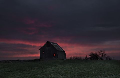 Isolated Barn Amid Vibrant Sunset Sky
