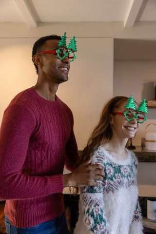 Cheerful Couple Holiday Style Wearing Christmas Tree Glasses