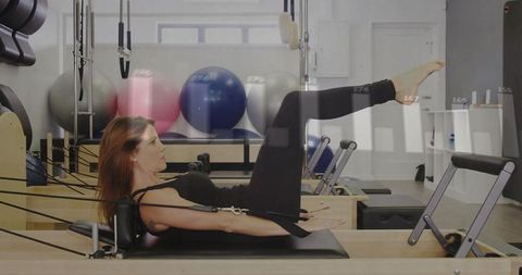 Woman Performing Pilates Leg Lift on Reformer Machine