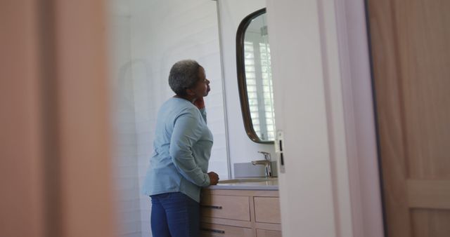 Senior Woman Looking in Bathroom Mirror Contemplative Moment - Download Free Stock Images Pikwizard.com